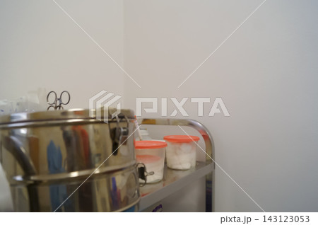 Sterile medical trolley with metal container and cotton jars in a clinic room. Healthcare preparation concept for hygiene, tools and clinical supplies Sterile medical trolley with metal container and cotton jars in a clinic room. Healthcare preparation concept for hygiene, tools and clinical supplies 143123053