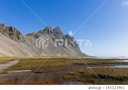 Vestrahorn Peaks Above Grassy Coastal Wetlands at Stokksnes, Iceland in Summer Vestrahorn Peaks Above Grassy Coastal Wetlands at Stokksnes, Iceland in Summer 143123461