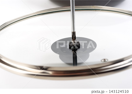 Assembling Pot Lid Knob by Tightening Screw with Screwdriver Close Up Assembling Pot Lid Knob by Tightening Screw with Screwdriver Close Up 143124510