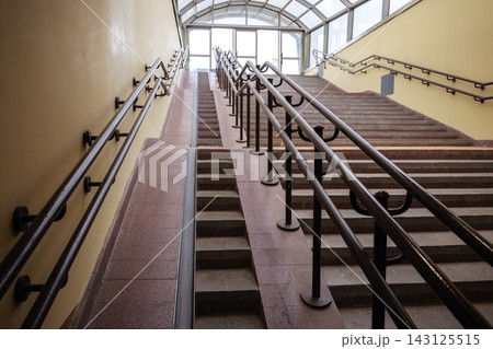 Concrete staircase with accessibility ramp and metal handrails providing barrier free environment at transit station Concrete staircase with accessibility ramp and metal handrails providing barrier free environment at transit station 143125515