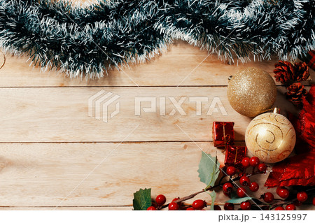 Rustic Christmas background featuring a decorative frame surrounding a large open space for text, set on a light wood table. 143125997