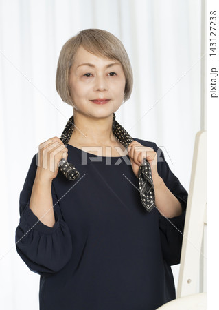 スカーフを選びオシャレをするシニア女性 143127238