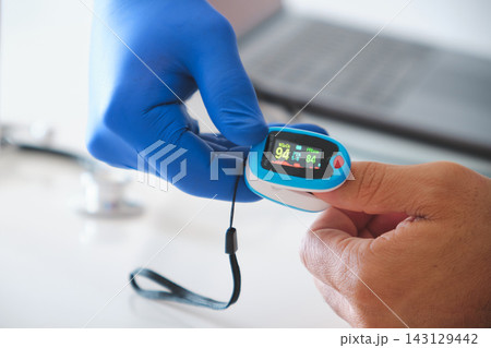 Doctor measuring patient blood oxygen with pulse oximeter Doctor measuring patient blood oxygen with pulse oximeter 143129442