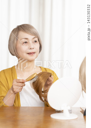 薄毛に悩みウイッグをつけるシニア女性 薄毛に悩みウイッグをつけるシニア女性 143130332