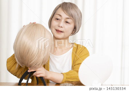 薄毛に悩みウイッグをつけるシニア女性 薄毛に悩みウイッグをつけるシニア女性 143130334