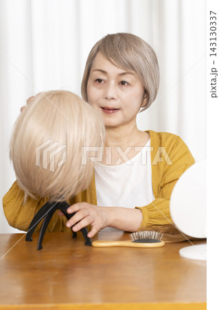 薄毛に悩みウイッグをつけるシニア女性 薄毛に悩みウイッグをつけるシニア女性 143130337