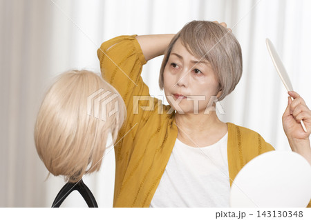 薄毛に悩みウイッグをつけるシニア女性 薄毛に悩みウイッグをつけるシニア女性 143130348