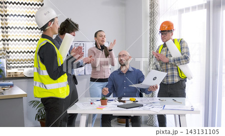The construction company staff applauds their boss. A group of builders, engineers and designers celebrates a job well done 143131105