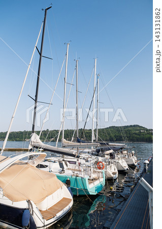 Boats moored beside a marina pier on a calm summer day 143131862