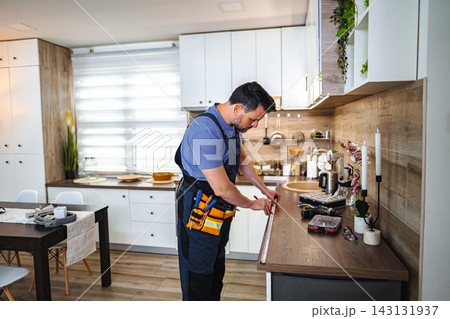 Handyman measuring kitchen countertop for home renovation project Handyman measuring kitchen countertop for home renovation project 143131937