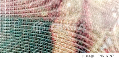 Close-up of a woven carpet fabric texture featuring an abstract pattern in green, pink, and cream Close-up of a woven carpet fabric texture featuring an abstract pattern in green, pink, and cream 143131971