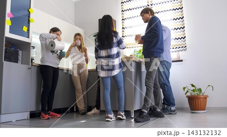 Friends drink tea or coffee standing in a cozy kitchen. Business lunch. Coffee break. A legitimate break from work Friends drink tea or coffee standing in a cozy kitchen. Business lunch. Coffee break. A legitimate break from work 143132132