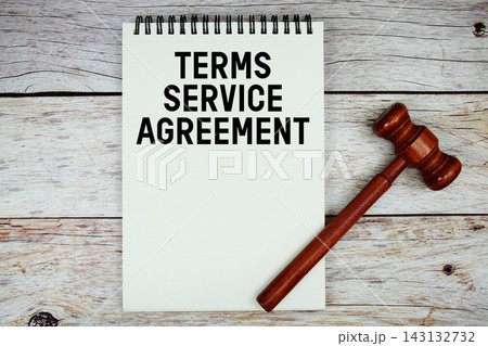 Terms Service Agreement text written on notepad with wooden judge gavel on wooden background Terms Service Agreement text written on notepad with wooden judge gavel on wooden background 143132732