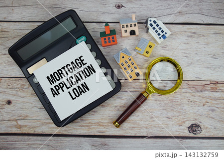 Mortgage Interest Rates text with house model, calculator and magnifying glass on wooden background 143132759