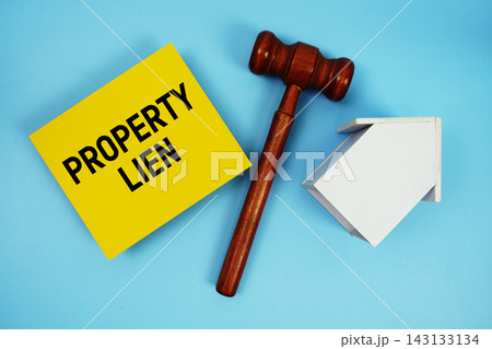 Property Lien text with judgment gavel and house model on blue background Property Lien text with judgment gavel and house model on blue background 143133134