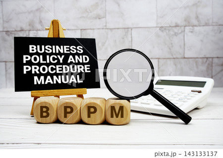 BPPM Business Policy and Procedure Manual text with calculator magnifying glass and on wooden background 143133137