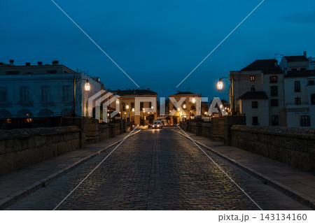 Symmetrical view down the cobblestone Puente Nuevo bridge at blue hour in Ronda, Spain Symmetrical view down the cobblestone Puente Nuevo bridge at blue hour in Ronda, Spain 143134160
