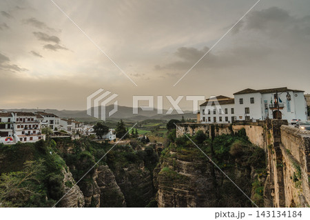 Green Tajo gorge and valley with whitewashed houses and hazy mountains in Ronda, Spain 143134184