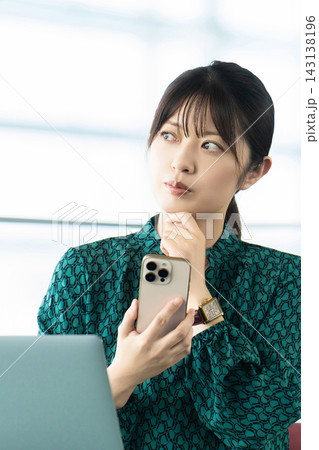 スマートフォンを持って考える女性・ビジネスウーマン 143138196