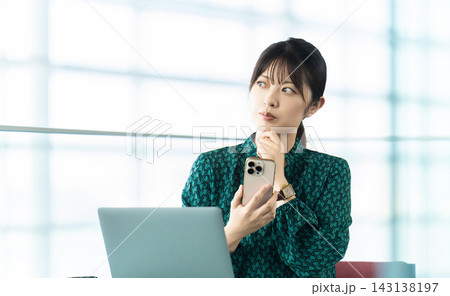 スマートフォンを持って考える女性・ビジネスウーマン 143138197