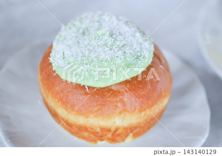 brioche donut or  doughnut or bun with green tea dressing or pandan custard and Coconut flakes topping 143140129