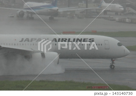 雨の滑走路に着陸する旅客機 エンジンの逆噴射の水煙 雨の滑走路に着陸する旅客機 エンジンの逆噴射の水煙 143140730