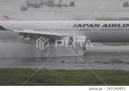 雨の滑走路に着陸する旅客機 エンジンの逆噴射の水煙 雨の滑走路に着陸する旅客機 エンジンの逆噴射の水煙 143140951