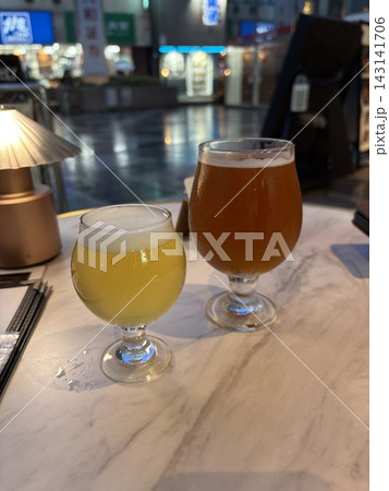 居酒屋で楽しむ2種類のクラフトビール　夜の飲食シーン 143141706