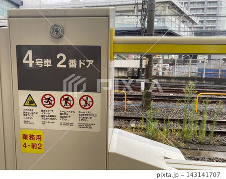 JR横浜線ホームドアの注意アイコンが並ぶ駅ホームの安全設備 143141707