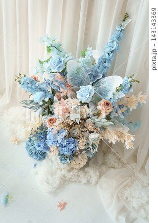 Delicate wedding bouquet of artificial light blue roses and pale pink flowers with butterflies Delicate wedding bouquet of artificial light blue roses and pale pink flowers with butterflies 143143369