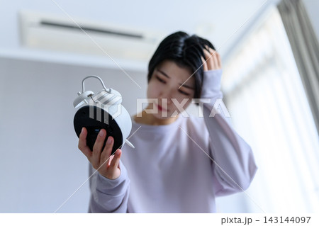 目覚まし時計を持つ女性 目覚まし時計を持つ女性 143144097