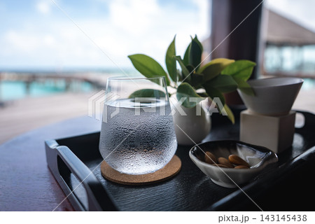 Chilled water and teaware on tray with overwater bungalows, Maldives Chilled water and teaware on tray with overwater bungalows, Maldives 143145438