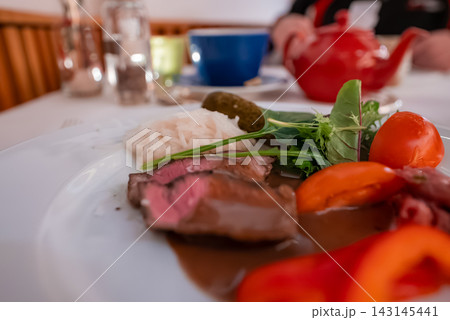 Medium rare sliced beef with arugula and sauce at Oberlech hotel 143145441