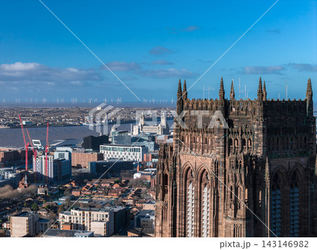 Aerial sunrise view of Liverpool shows Liverpool Cathedral, Royal Liver Building, Albert Dock museums, red cranes, modern blocks, and offshore wind turbines. Aerial sunrise view of Liverpool shows Liverpool Cathedral, Royal Liver Building, Albert Dock museums, red cranes, modern blocks, and offshore wind turbines. 143146982