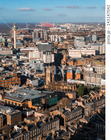 Aerial sunrise view of Liverpool with Radio City Tower left and St Luke's ruins centered. River Mersey, port cranes, wind turbines, St George's Hall, and modern blocks appear. 143147042