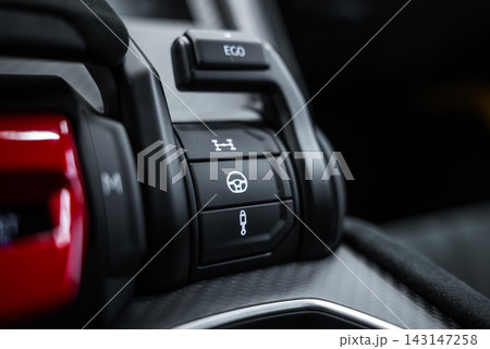 Close up of Lamborghini Urus Performante center console shows EGO switch, differential, steering, and suspension buttons on carbon fiber trim with soft studio lighting. 143147258