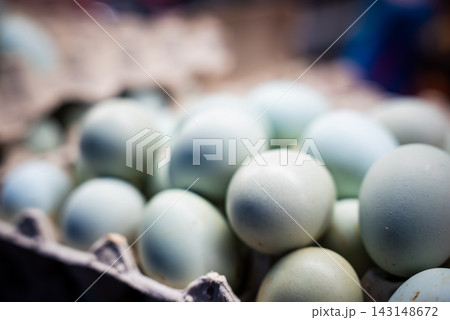 Matte blue green eggs fill a carton at Riga Central Market. Soft light and shallow focus isolate speckled shells as morning vendors present regional offerings. 143148672