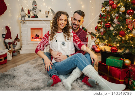 Happy couple celebrating Christmas at home during winter holidays 143149789