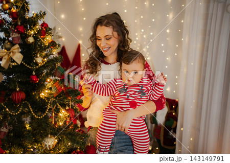 Mother holding baby celebrating Christmas at home 143149791