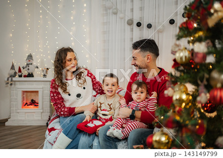 Family celebrating Christmas holidays together in living room Family celebrating Christmas holidays together in living room 143149799