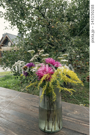 Colorful autumn wildflower bouquet in a ribbed glass vase outdoors Colorful autumn wildflower bouquet in a ribbed glass vase outdoors 143150288