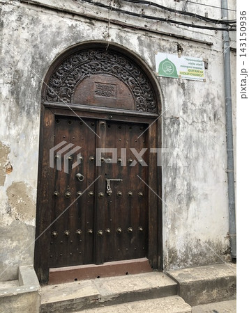 Old wooden door in a weathered Stone Town wall 143150936