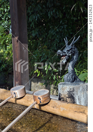 龍の吐水口と竹の柄杓が並ぶ神社の手水舎 143152623