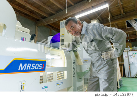 籾摺り機で作業を確認する農家の男性 籾摺り機で作業を確認する農家の男性 143152977