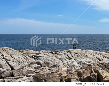 Rock cairns stacked on coastal granite shore 143153219