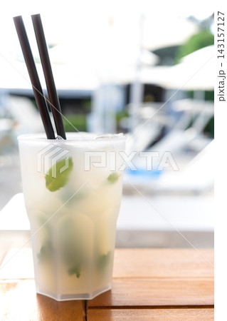 真夏の昼間にリゾートホテルのプールサイドで飲むカクテルのモヒート 真夏の昼間にリゾートホテルのプールサイドで飲むカクテルのモヒート 143157127
