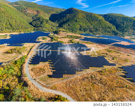 Solar panel farm located in a mountainous area with green hills and blue sky on a sunny day Solar panel farm located in a mountainous area with green hills and blue sky on a sunny day 143158324