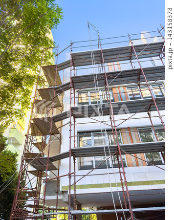 Construction work on a building with scaffolding in an urban area during the day 143158378