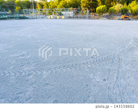 Ground covered with fine gray sand in a construction area near trees in a quiet location during the late afternoon Ground covered with fine gray sand in a construction area near trees in a quiet location during the late afternoon 143158602