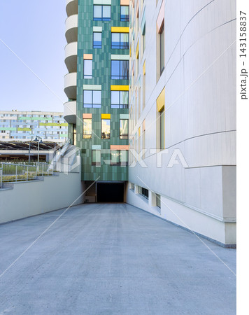 Building entrance with a sloped driveway and colorful wall design during daylight hours in an urban area Building entrance with a sloped driveway and colorful wall design during daylight hours in an urban area 143158837